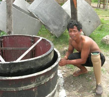 Sim Bung Seng, with an artificial limb, makes concrete